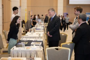 A visitor speaking with a university representative at a stand during the 28th GESCO Education Fair