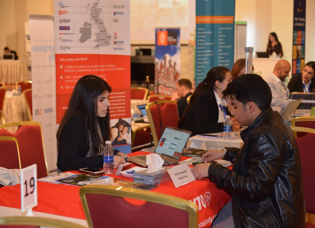 Students speaking with representatives at a university stand