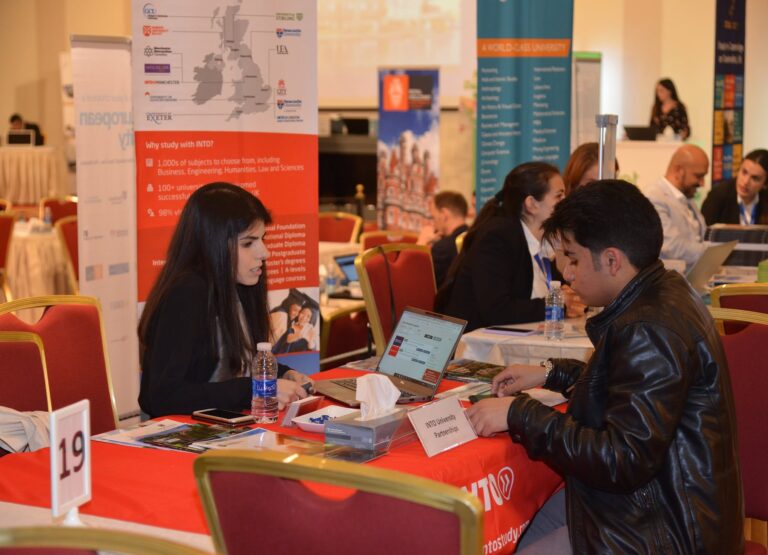 Students speaking with representatives at a university stand