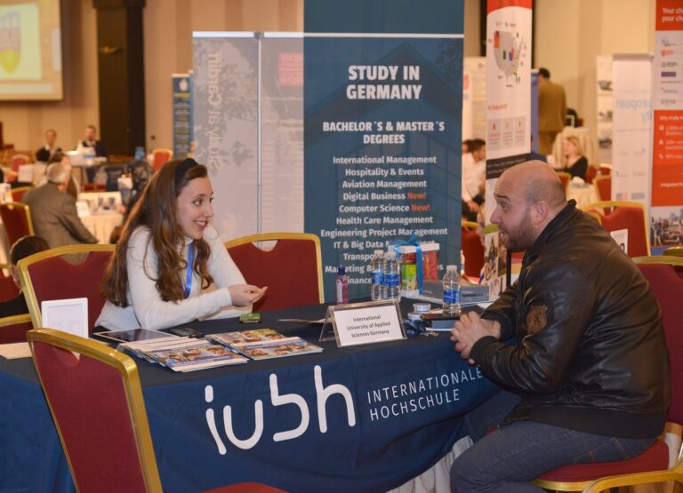 The IUBH stand, with a representative meeting a student